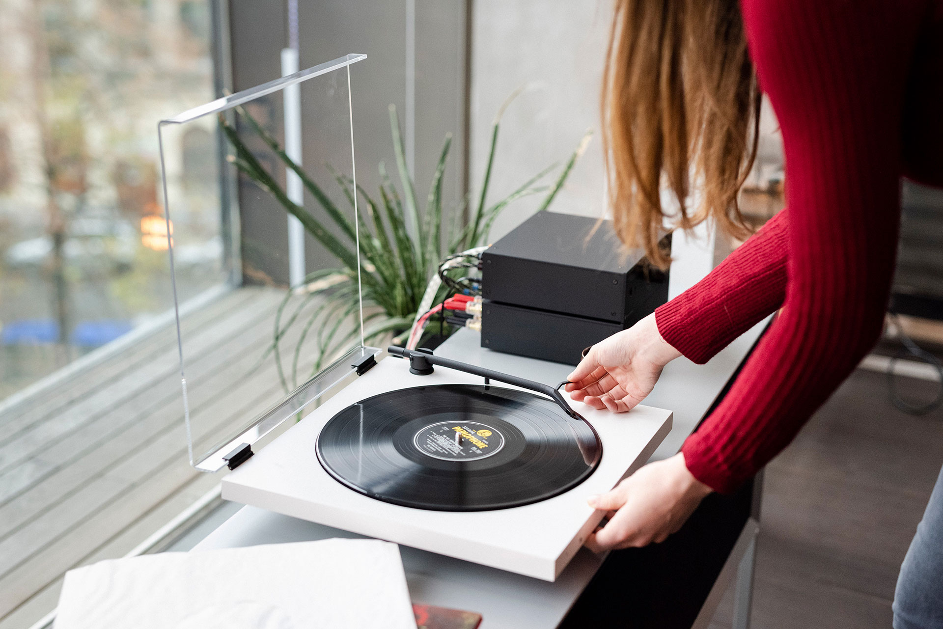 Woman plays vinyl record on TONE FACTORY record player..