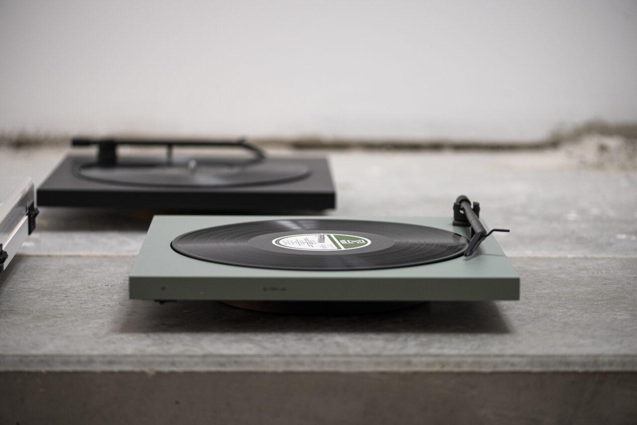 Tone turntable recordplayer green satin black satin vinyl record, on concrete floor with with wall