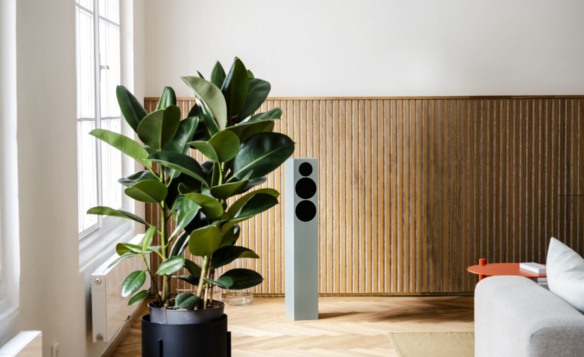 White TONE speaker L in modern living space behind a green plant