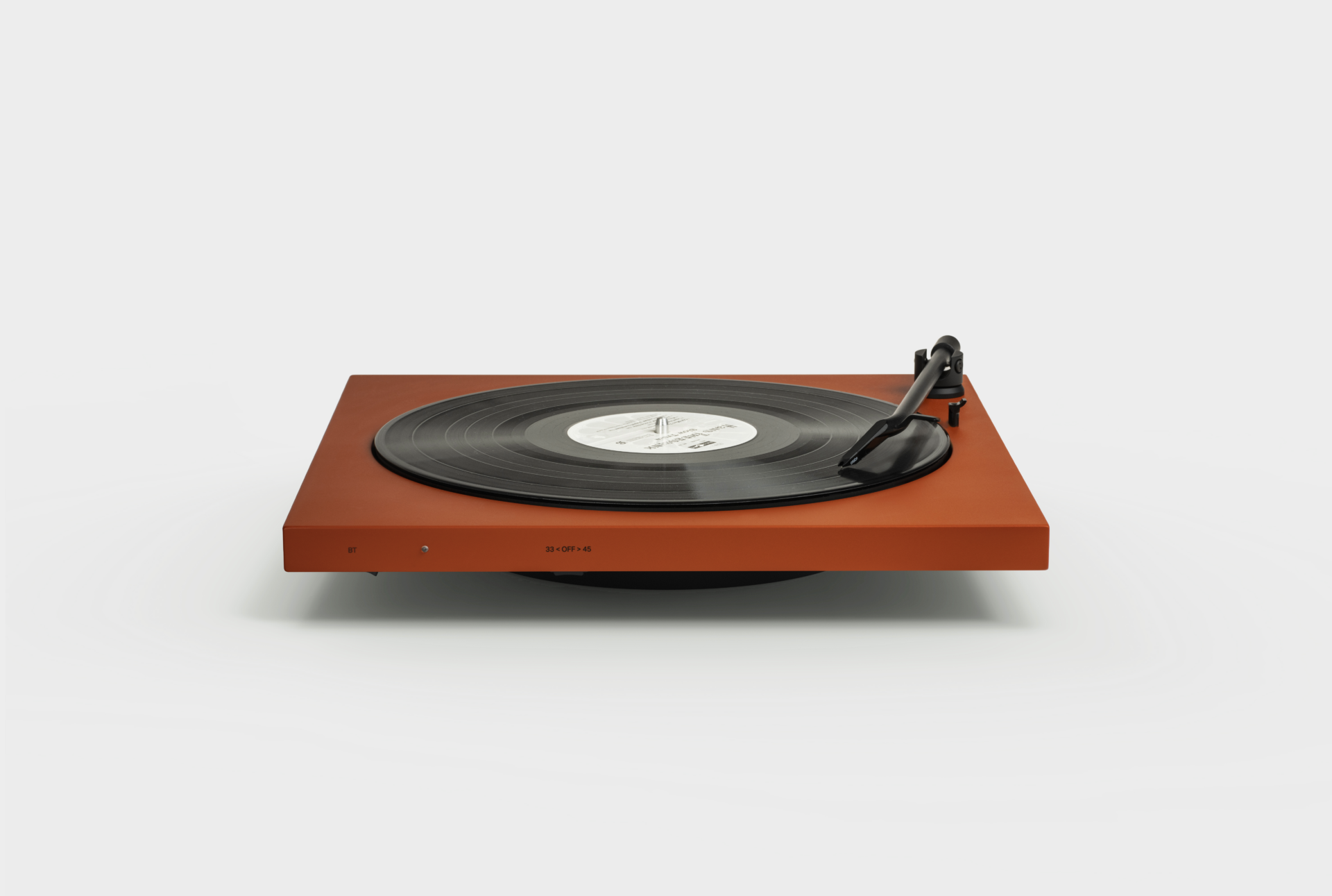 TONE record player in terracotte red with a record playing