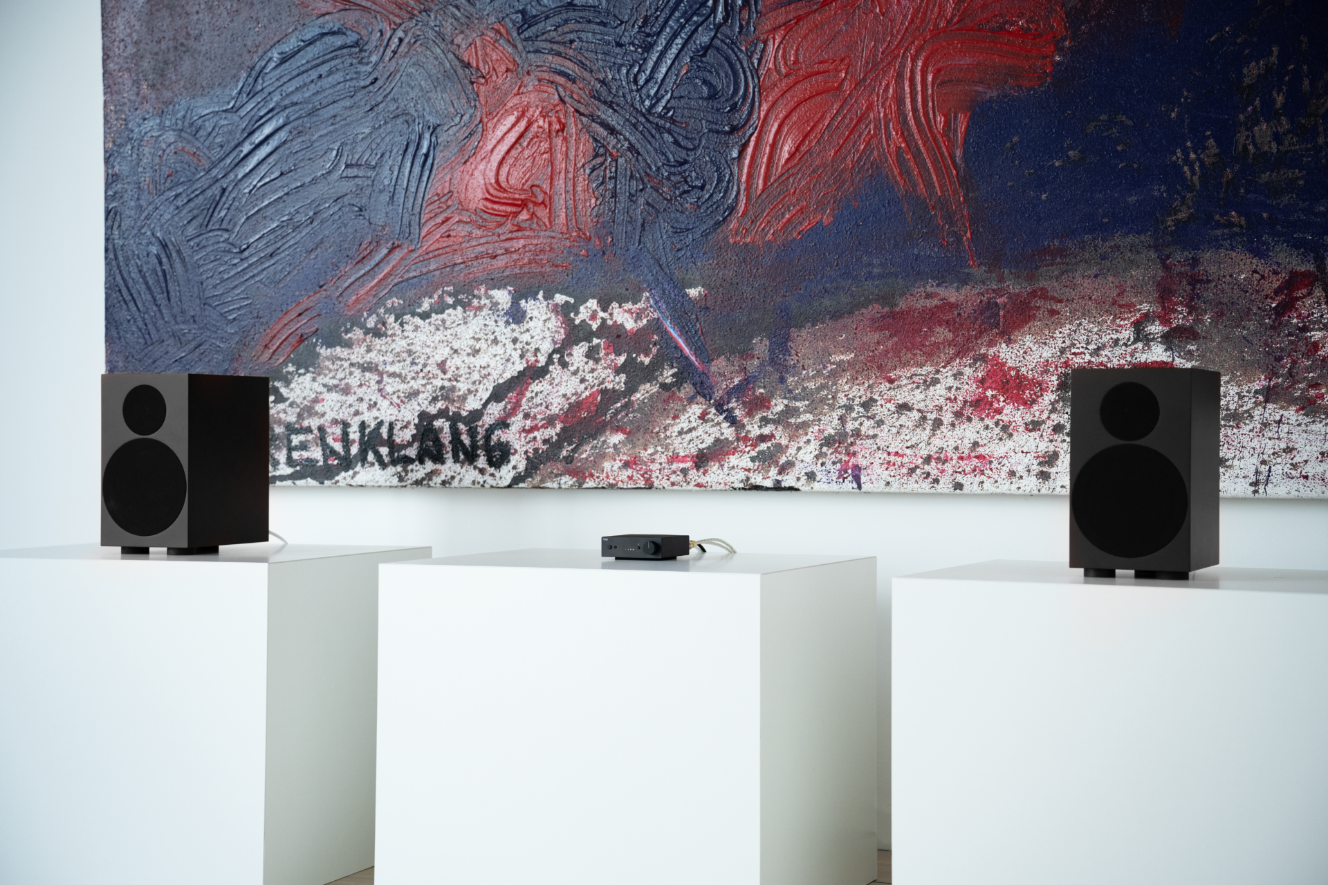TONE Stereo Set S including TONE Speaker S and the Tone Amp. The Stereo Set is standing on white boxes with art in the background